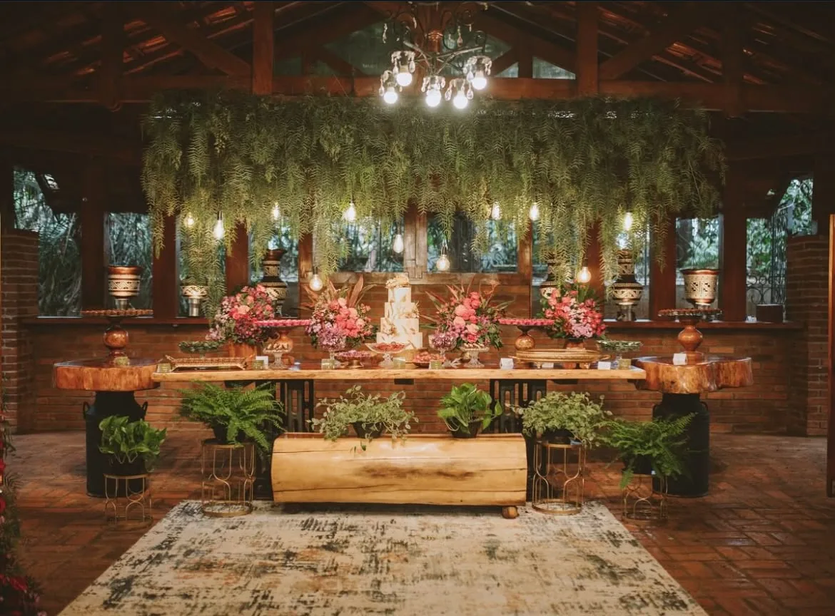 Mesa de doces decorada com samambaias e luzes